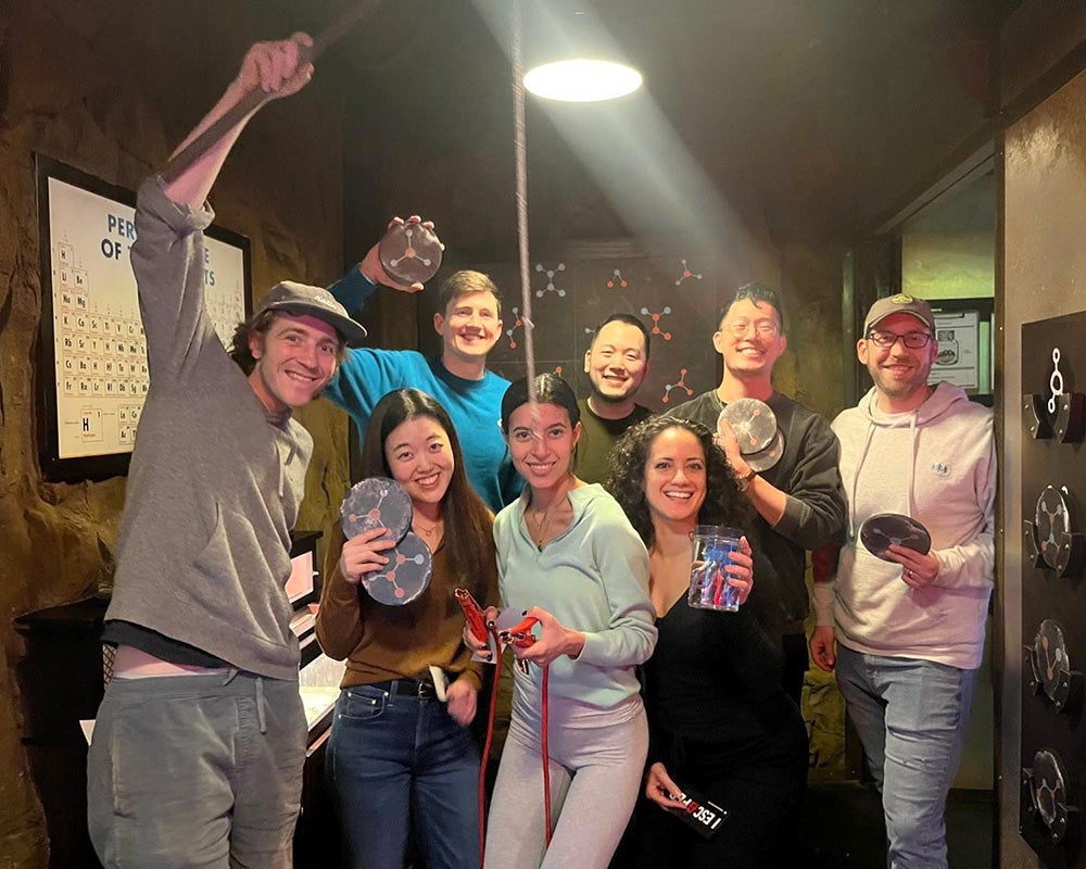 A group of residents stands in an escape room holding various props