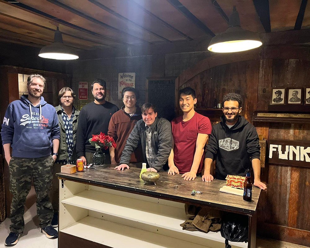 A group of residents stands together in a bar setting