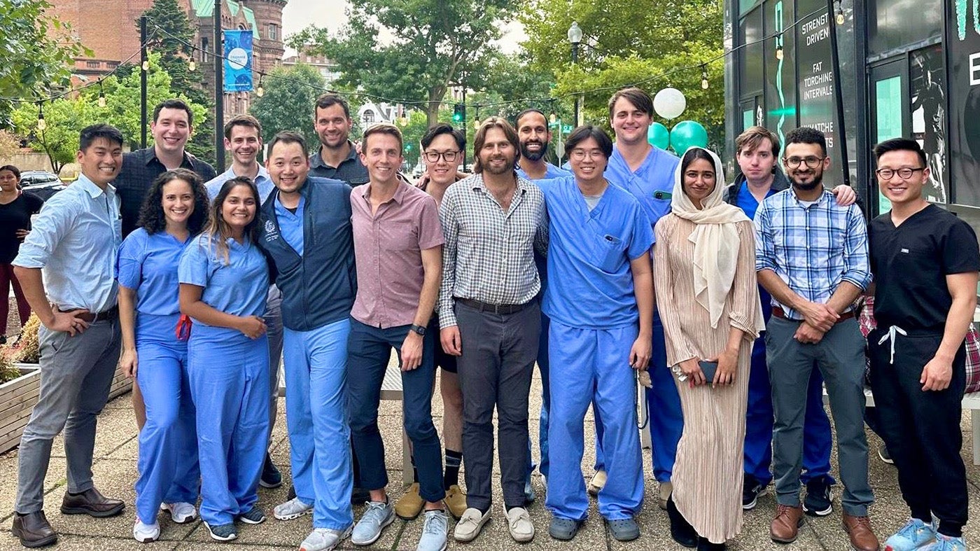 A group of medical residents stand together on an urban street